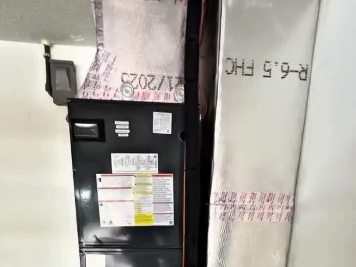 Air handler installed in a garage beside insulated ductwork