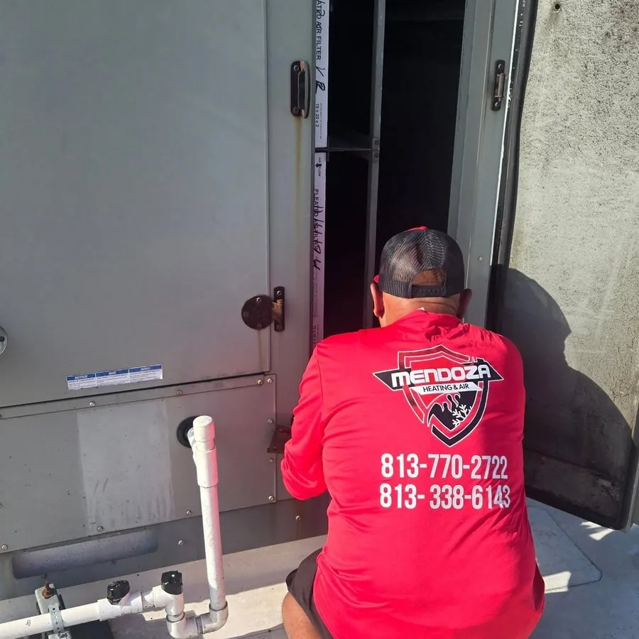 Mendoza Heating and Air technician servicing a rooftop unit in Tampa